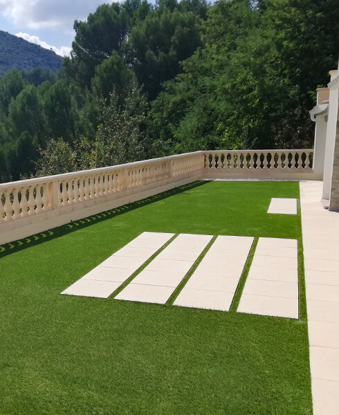 Gazon synthétique sur une terrasse avec balustres
