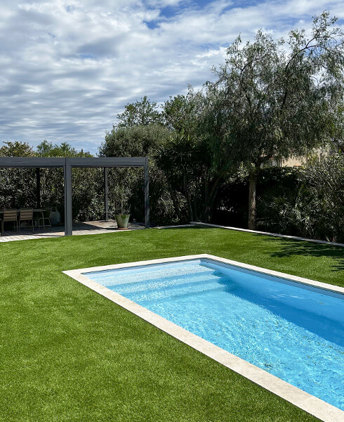 Espace extérieur avec piscine et pelouse artificielle