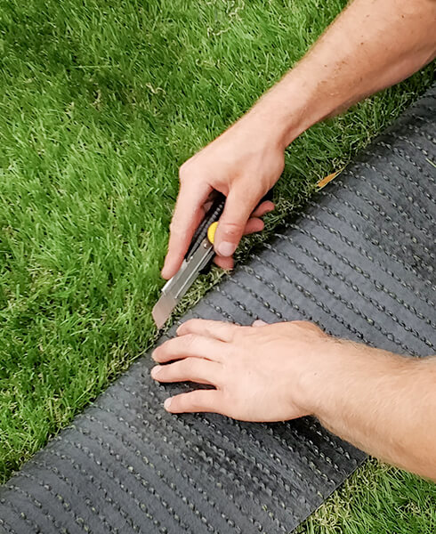 Découpe de gazon synthétique dans un jardin